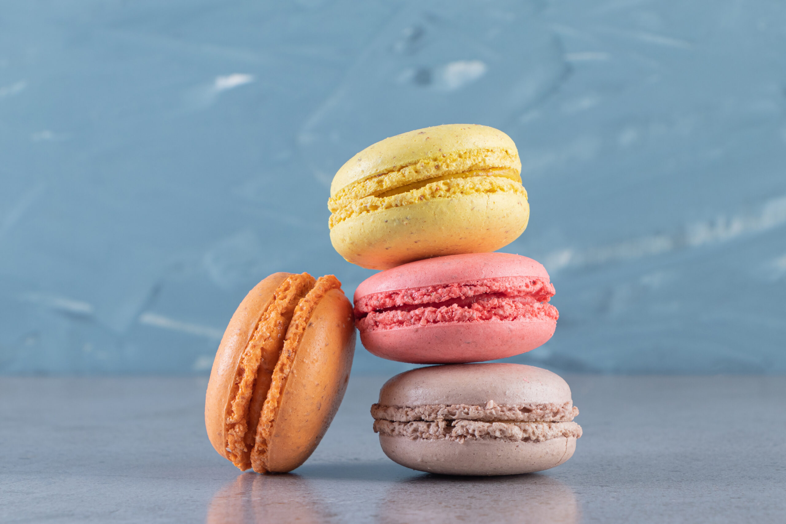 Creamy colorful sweet macaroons placed on marble background. High quality photo